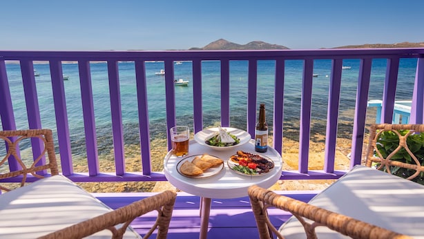 A table with food and drinks on a balcony overlooking the sea. - The Colourful Land Klima, Milos (Klima)