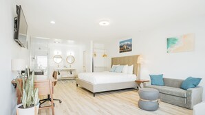 A modern hotel room with a bed, a sofa, a desk, and a potted plant. - SKS - Superior Room, 1 King Bed with Sofa bed, Non Smoking (Long Beach)