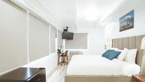 A modern hotel room with a large bed, a desk, and a television. - DK - Deluxe Room, 1 King Bed, Non Smoking (Long Beach)