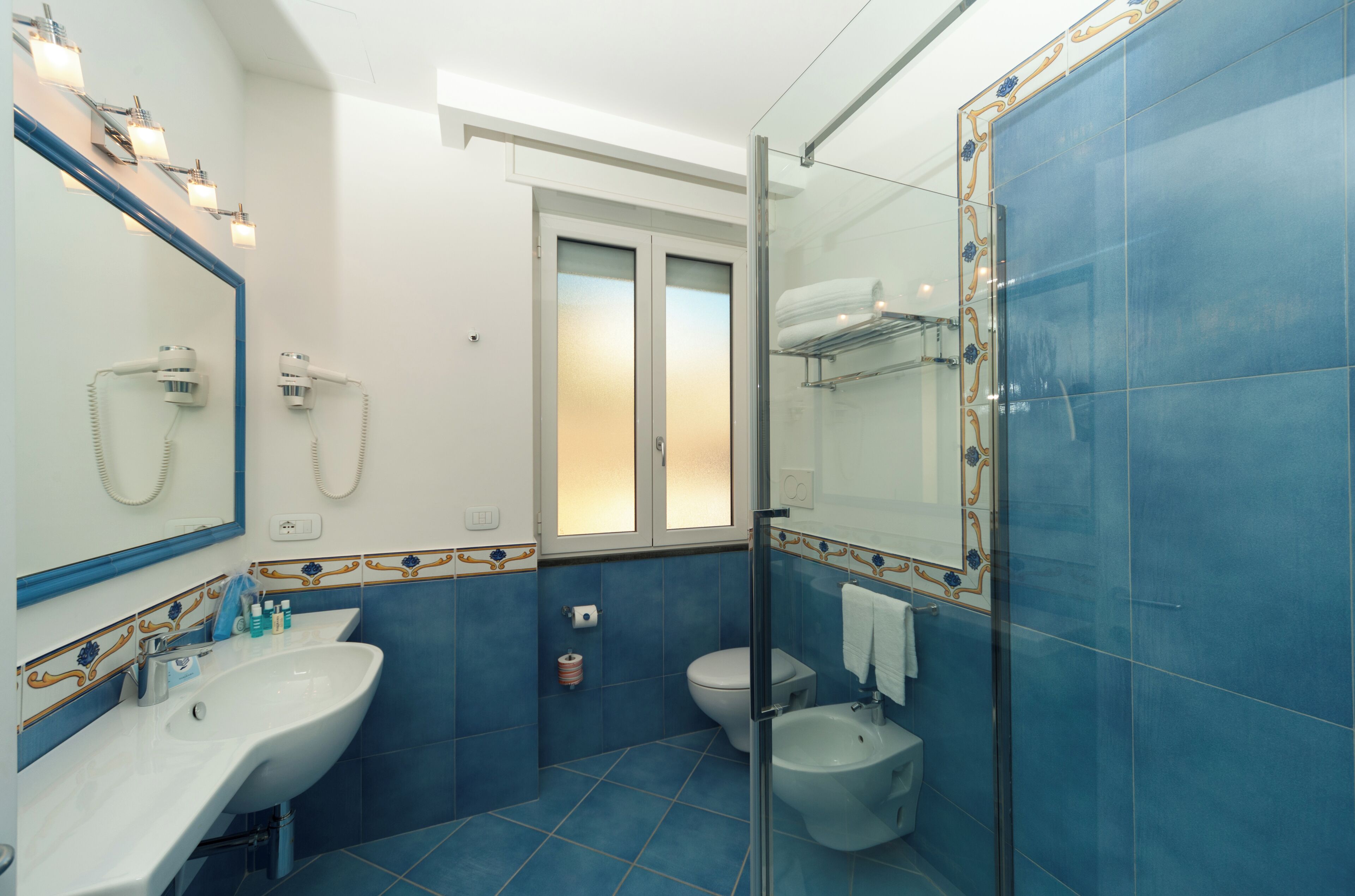 A bathroom with a sink, toilet, and shower area.