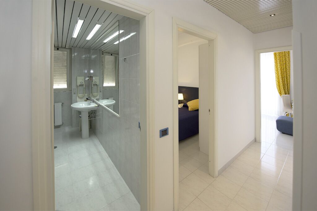 A modern bathroom with a glass shower enclosure, a sink, and a mirror.