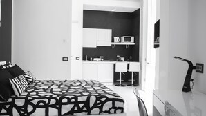 Een moderne hotelkamer met een groot bed, een kitchenette en een badkamer.