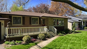 A single-story house with a front porch, a brick exterior, and a well-maintained lawn.