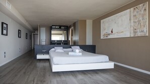 Une chambre à coucher moderne avec un grand lit, un design minimaliste et un tableau accroché au mur.