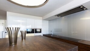 Une cuisine moderne dotée d’un îlot central, d’appareils électroménagers intégrés et d’un design épuré.