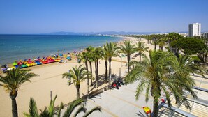 Une plage bordée de palmiers, une étendue de sable et un ciel bleu azur.