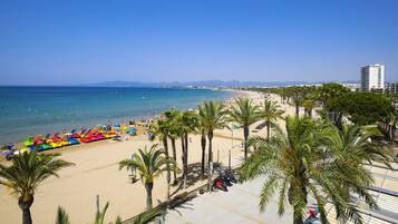 Ein Strand mit Palmen, sandigem Ufer und blauem Himmel.