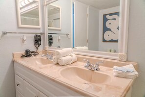 A bathroom with two sinks, a large mirror, and a towel rack. - Meridian 503 (Myrtle Beach)