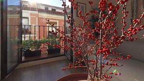A balcony with a potted plant and a view of a building.