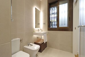 Ein modernes Badezimmer mit Toilette, Waschbecken und Waschtisch.