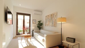 A modern living room with a sofa, a coffee table, a lamp, and a small table with a radio.