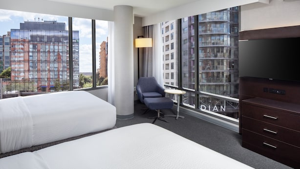 A hotel room with two beds, a desk, a chair, a TV, and large windows with a city view. - Holiday Inn Express Washington DC Downtown by IHG (Washington)