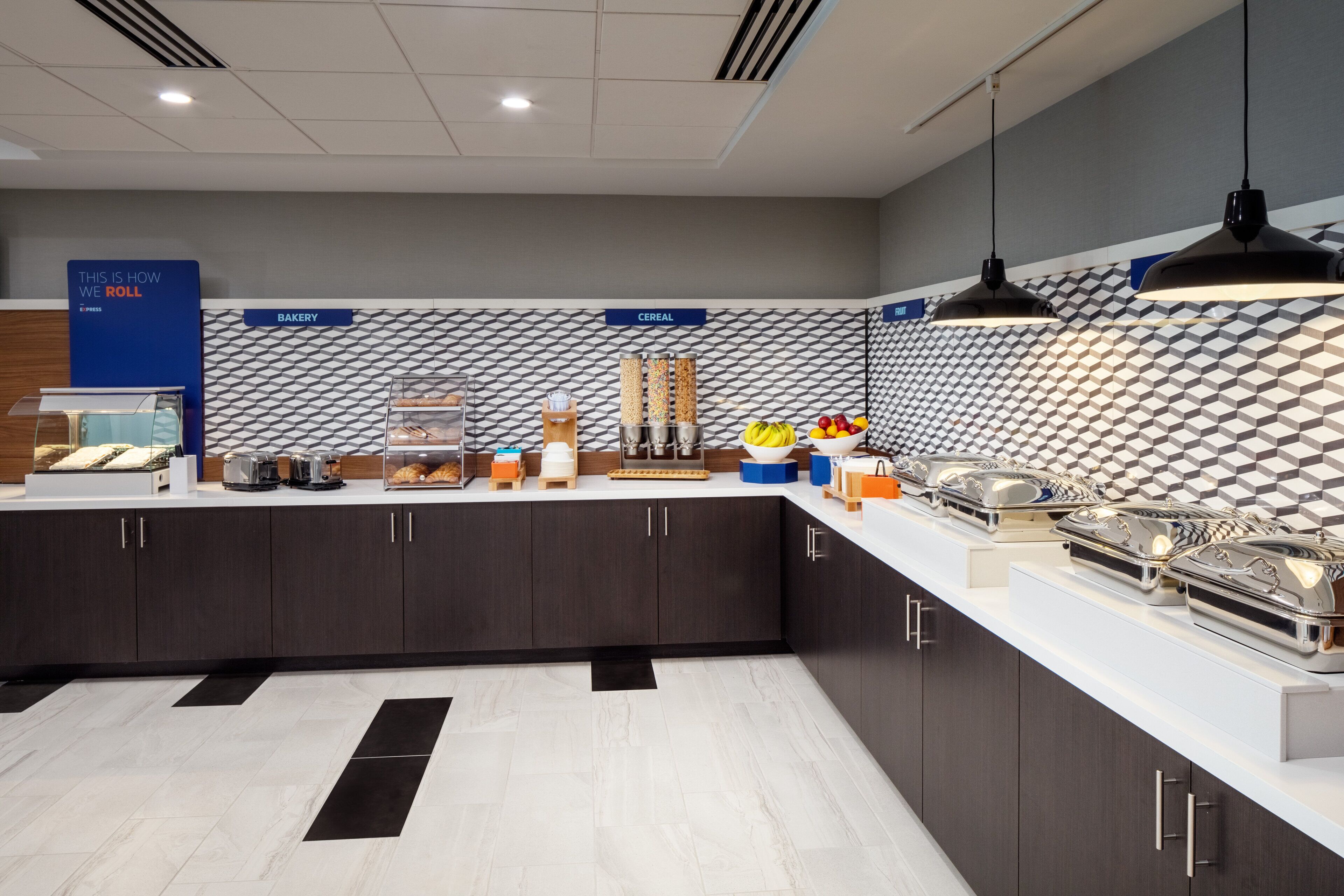 A modern kitchen with a geometric patterned backsplash, a bakery section, and a cereal display.