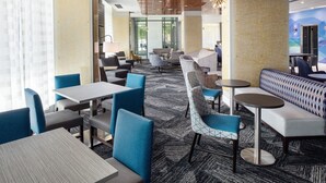 A modern hotel lobby with seating areas, tables, and a patterned carpet. - Holiday Inn Express Washington DC Downtown by IHG (Washington)