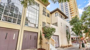 Um edifício moderno com amplas janelas e uma escadaria que dá acesso a uma garagem.