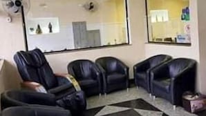Un área de espera con varias sillas de cuero negro dispuestas en fila.