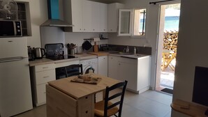 Eine kompakte Küche mit weißen Schränken, einem Backofen, einer Mikrowelle und einem Spülbecken.
