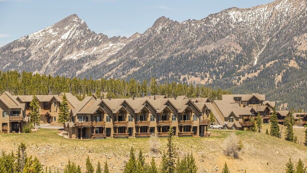 Un chalet doté de plusieurs cabanes, chacune offrant un balcon et une vue sur les montagnes environnantes.