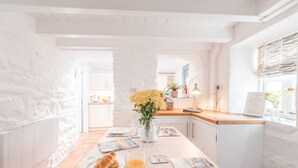 Ein Frühstückstisch mit Croissants, Orangensaft und einer Blumenvase.