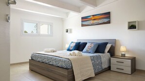 Een slaapkamer met een bed, nachtkastje en een schilderij aan de muur.