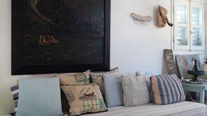 Una stanza con un letto, un grande quadro astratto e una finestra con tende.