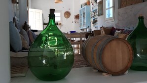 Una stanza con una grande bottiglia verde, una botte di legno e un armadietto blu.