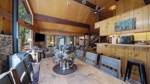A spacious wooden dining area with a large table, chairs, and a fireplace. - Woodsy Mountain Cabin - Best Location In Graeagle (Graeagle)