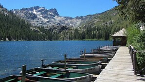 A row of rowboats docked at a wooden pier with a mountainous backdrop. - Woodsy Mountain Cabin - Best Location In Graeagle (Graeagle)
