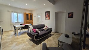 Un salon moderne comprenant un canapé, une table à manger et un coin cuisine.