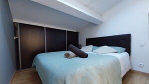 Une chambre à coucher avec un lit, une table de chevet et une armoire.