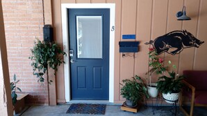 A front door with a mailbox, a potted plant, and a wall-mounted decorative piece. - Cozy Hideaway in Town (Springdale)