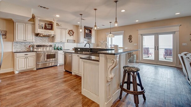 A spacious kitchen with a large island, stainless steel appliances, and a view to a balcony. - Sea Esta- Front Row Views-4 bedroom 3-1/2 bath home, sleeps 12 guests. (Port Bolivar)