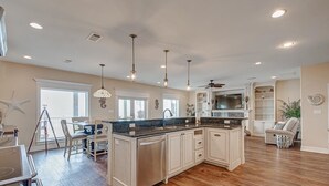 A spacious kitchen with a large island, pendant lights, and a built-in TV. - Sea Esta- Front Row Views-4 bedroom 3-1/2 bath home, sleeps 12 guests. (Port Bolivar)