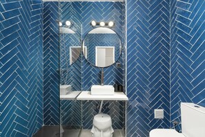 Ein Badezimmer mit Spiegel, Waschtisch und Toilette.