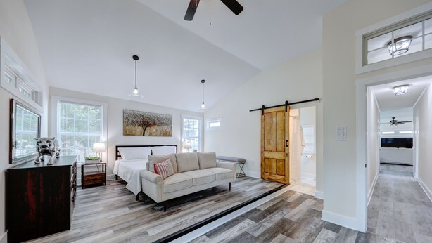 A spacious living room with a large sofa, a wooden coffee table, and a sliding barn door. - Pet Friendly Linens Included Rehoboth Beach House Parking Mini Golf (Rehoboth Beach)