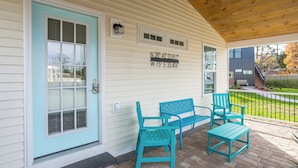 A porch with a light blue door, two blue chairs, and a small table. - Pet Friendly Linens Included Rehoboth Beach House Parking Mini Golf (Rehoboth Beach)