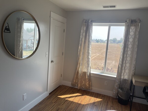 A room with a large window, a door, and a mirror on the wall. - Bozeman Basecamp - Full House - Backyard (Bozeman)