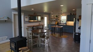 A modern kitchen with a central island, wooden chairs, a built-in stove, and a dining table. - Bozeman Basecamp - Full House - Backyard (Bozeman)