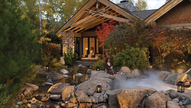 A traditional Japanese-style house with a stone exterior, a wooden deck, and a hot spring area with rocks and lanterns. - Suncadia Resort (Cle Elum)
