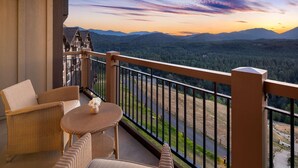 A balcony with wicker furniture and a view of a forested valley. - Suncadia Resort (Cle Elum)