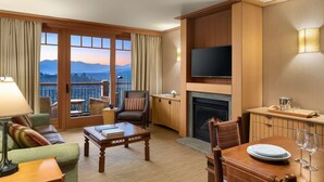 A hotel room with a balcony, a fireplace, a television, and a dining area. - Suncadia Resort (Cle Elum)
