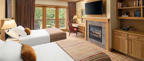 A hotel room with two beds, a TV, a fireplace, a bookshelf, and a desk with a chair.