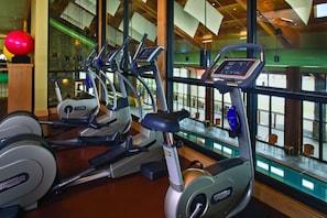 A gym with multiple treadmills, a red exercise ball, and a view of the outside through large windows. - Suncadia Resort (Cle Elum)