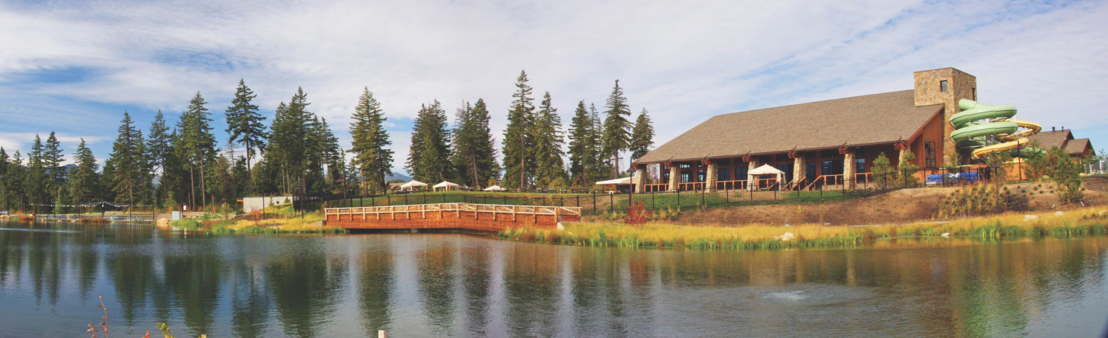 A lodge with a large building, a dock, and a lake.