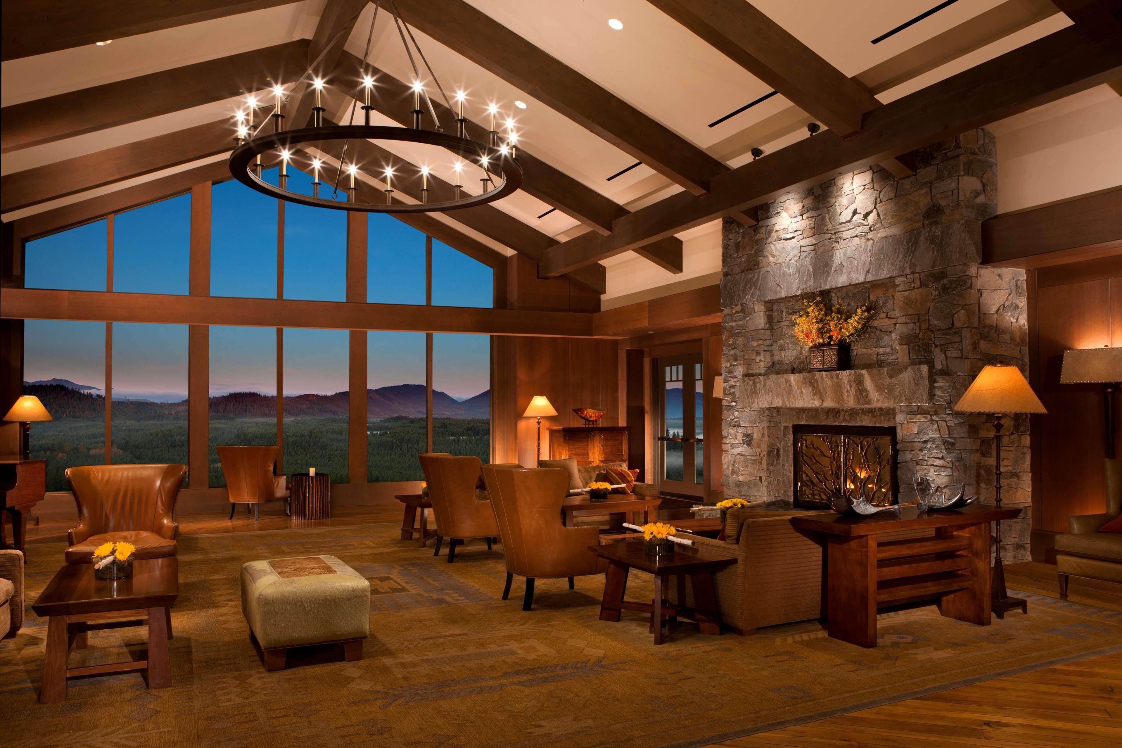 A spacious lobby with a large stone fireplace, multiple seating areas, and a chandelier.