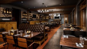 A restaurant with wooden tables, leather booths, and pendant lighting. - Suncadia Resort (Cle Elum)