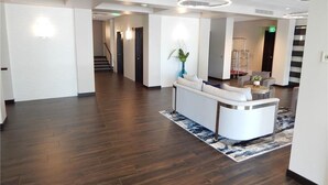 A spacious lobby with a reception desk, a staircase, and a modern ceiling design. - Walk out the back door to #1 beaches in Naples. Renovated with new Furnishings. (Naples)
