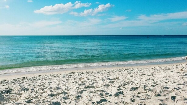 A beach with clear blue water and a sandy shore. - Walk out the back door to #1 beaches in Naples. Renovated with new Furnishings. (Naples)