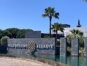 En skylt för Vale Dolobo Algarve med en modern byggnad i bakgrunden.