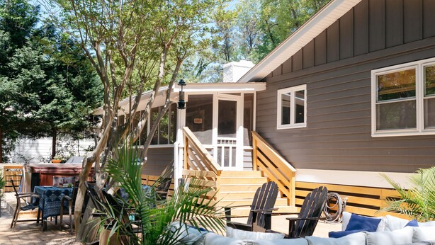 A deck with outdoor furniture, a potted plant, and a house with a covered porch. - Peaceful Beach Retreat in Southern Shores.Beach Front Parking Passes included (Kitty Hawk)